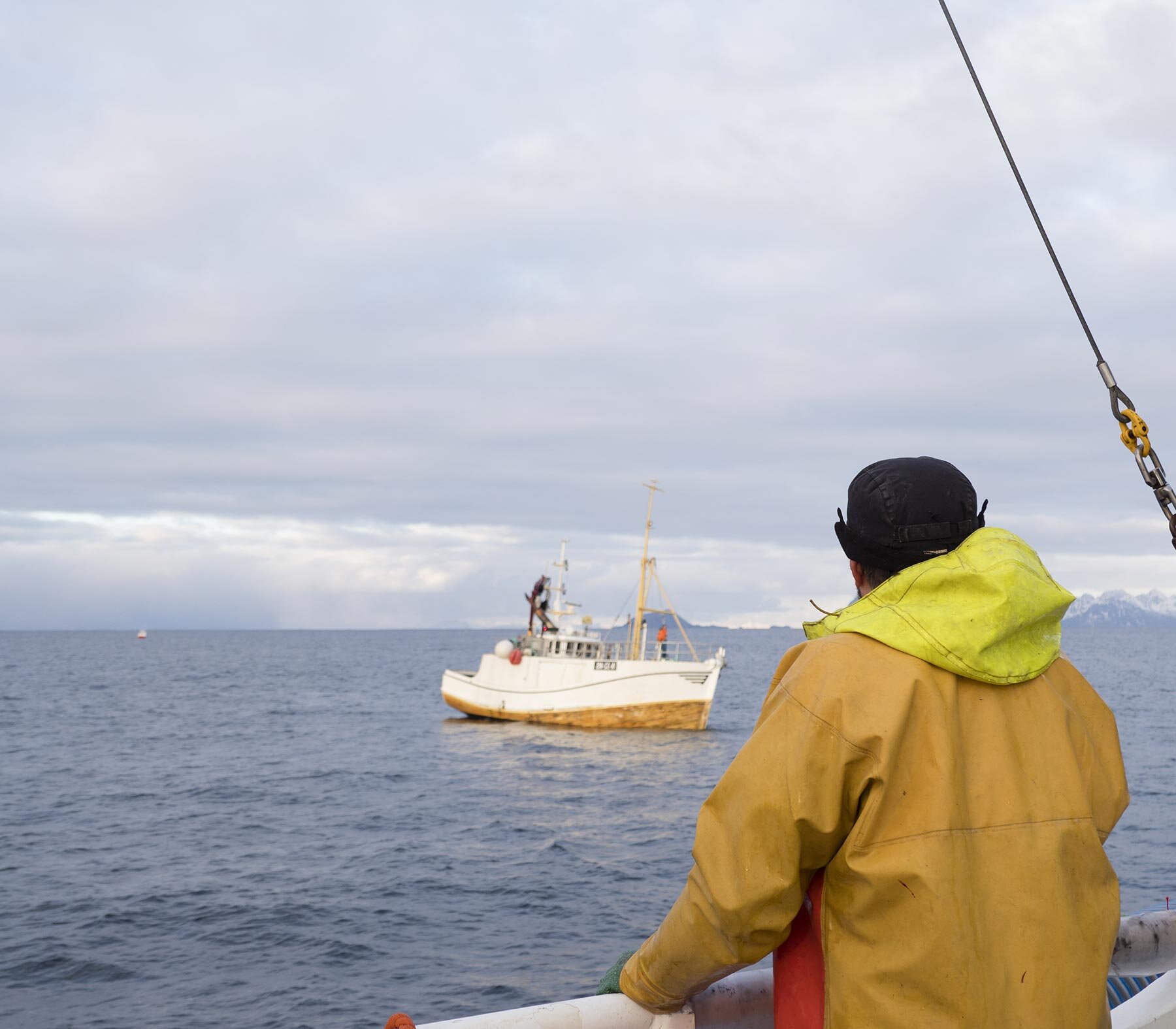 Fisherman at sea lookin at another fishing boat